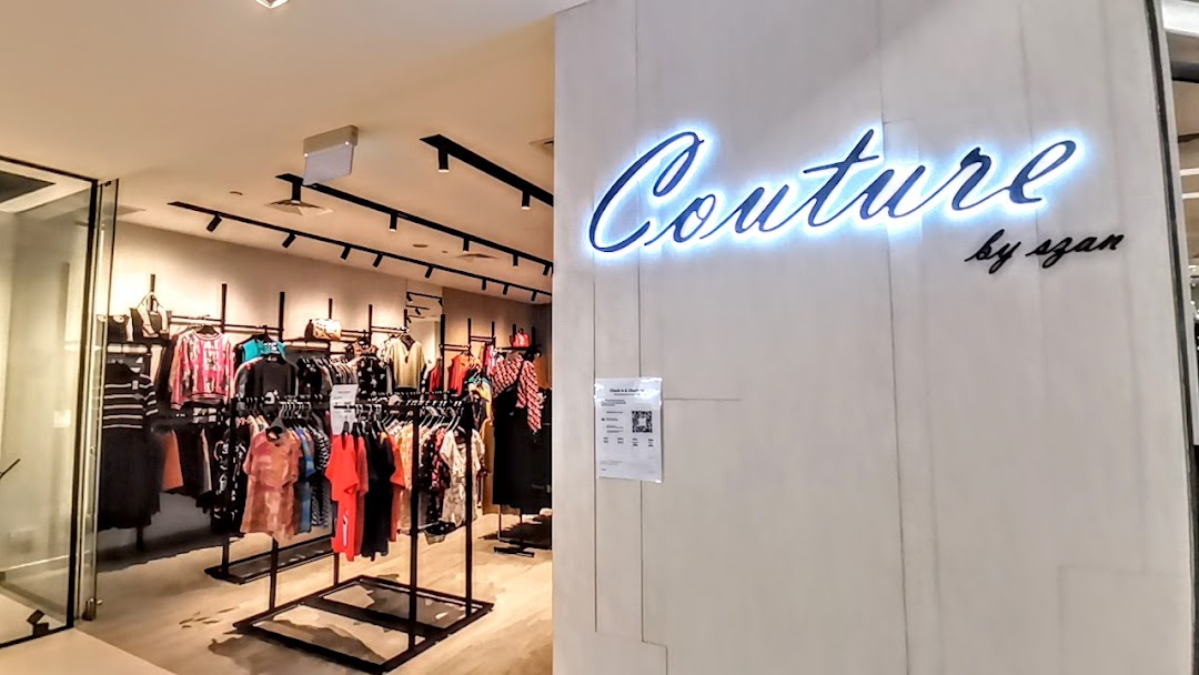 View of Couture by szan's illuminated entrance and vibrant clothing displays inside.