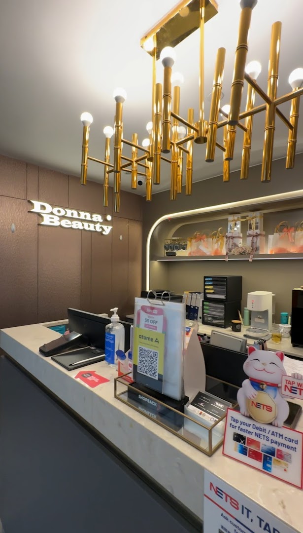 An interior shot of Donna Beauty's reception area, featuring a prominent logo, modern decor, and payment counter.