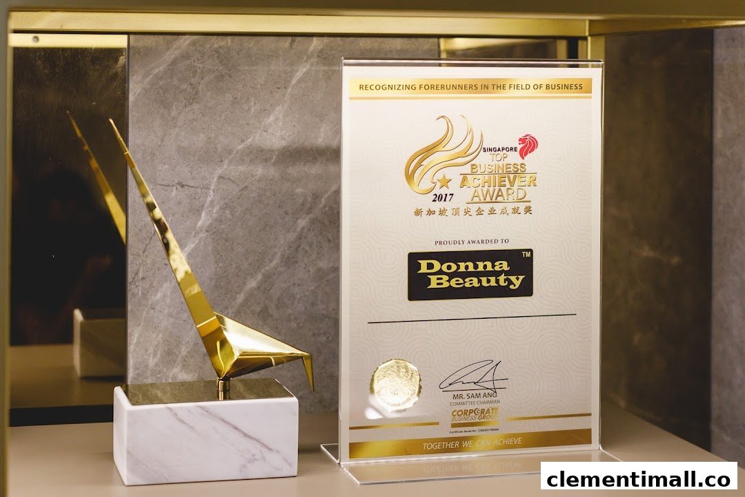 A golden trophy displayed next to the 'Singapore Top Business Achiever 2017' award for Donna Beauty.