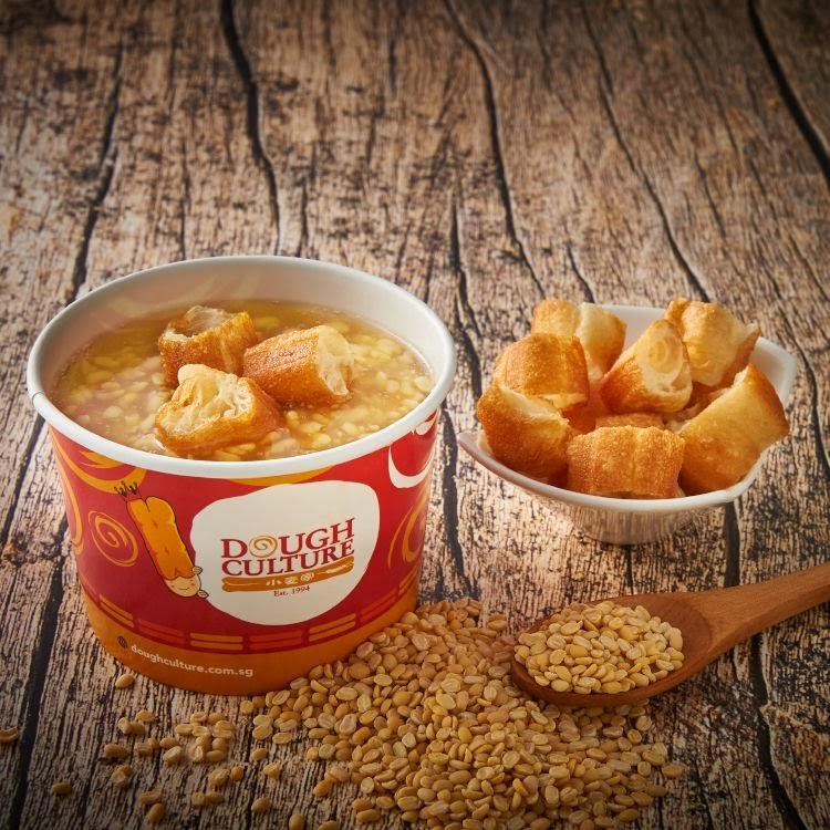 A bowl of traditional dessert soup with fried dough sticks, alongside soybeans.