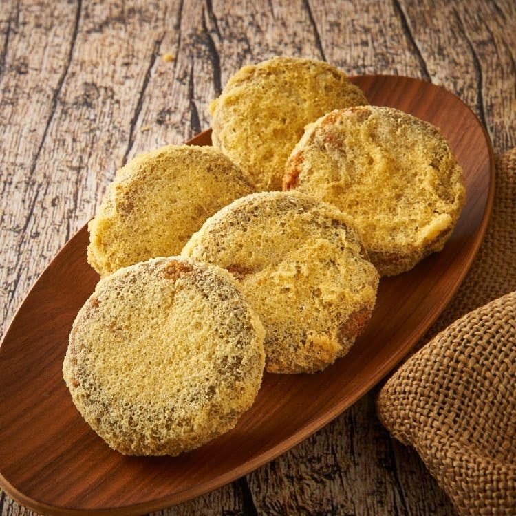 A wooden platter holds several golden-brown, round pastries or snacks, likely from Dough Culture.