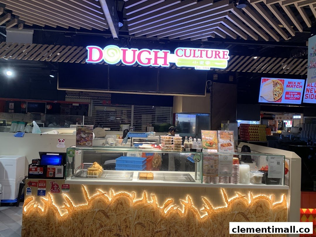 A vibrant counter display at Dough Culture, featuring its illuminated sign and fresh baked goods.