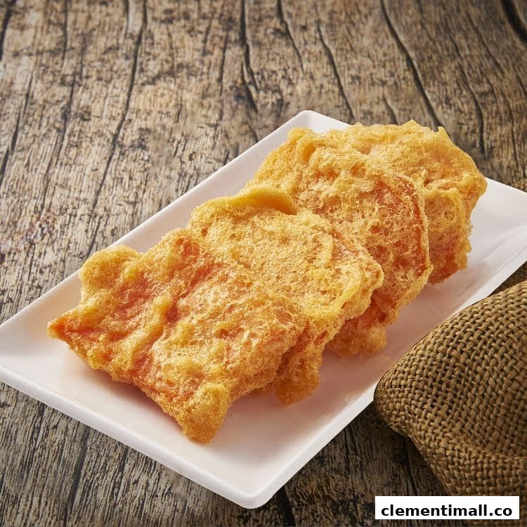 A plate of golden-fried crispy dough snacks on a rustic wooden surface, with a burlap sack.