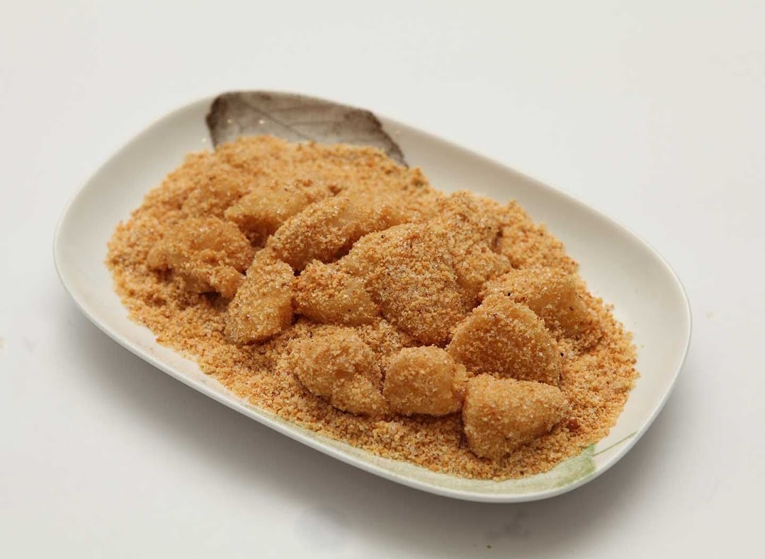 A plate of traditional glutinous rice cakes coated in finely ground peanut powder.