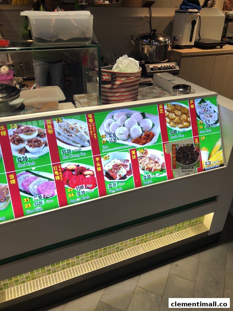 A vibrant display counter showcasing various traditional Asian snacks and their prices.