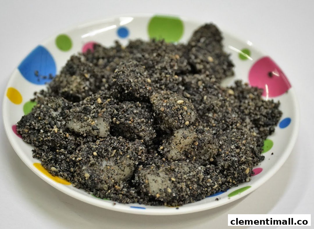 A plate of traditional rice cakes coated generously with black sesame and sugar.