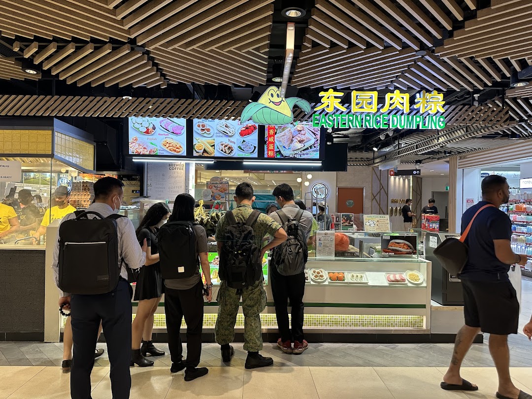 Customers queue at Eastern Rice Dumpling, featuring digital menus and food displays.
