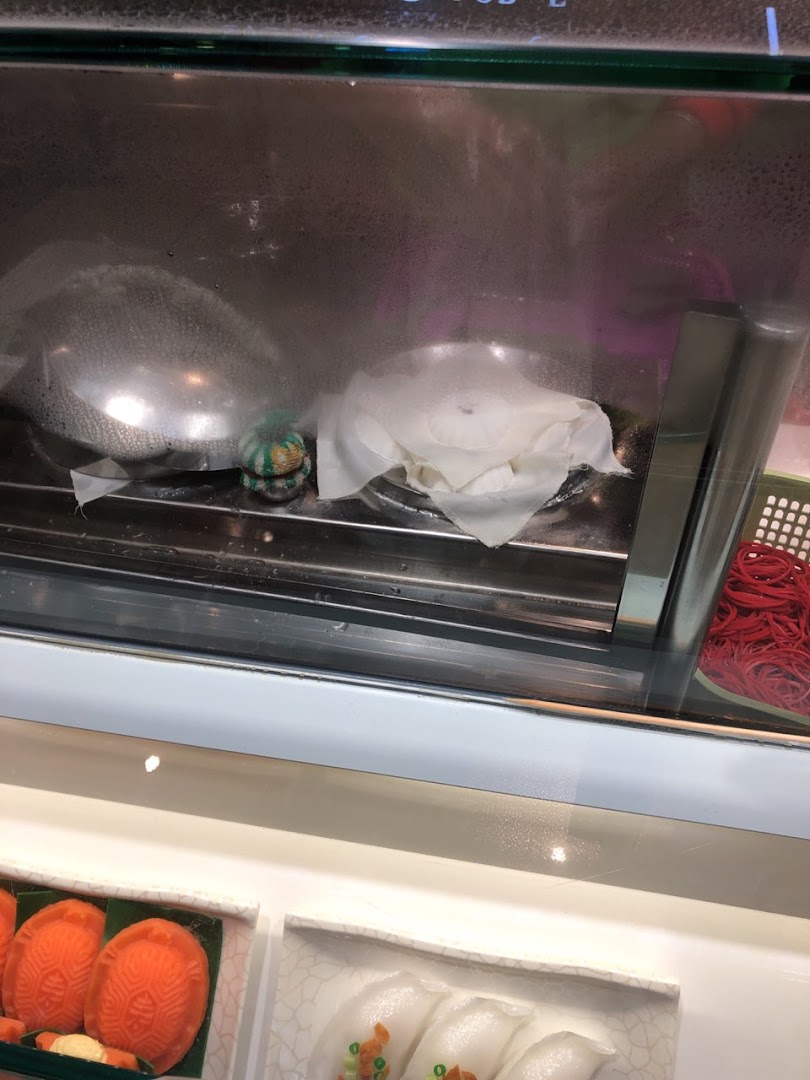 A close-up of a steamed display case showcasing traditional Asian pastries and dumplings at Eastern Rice Dumpling.