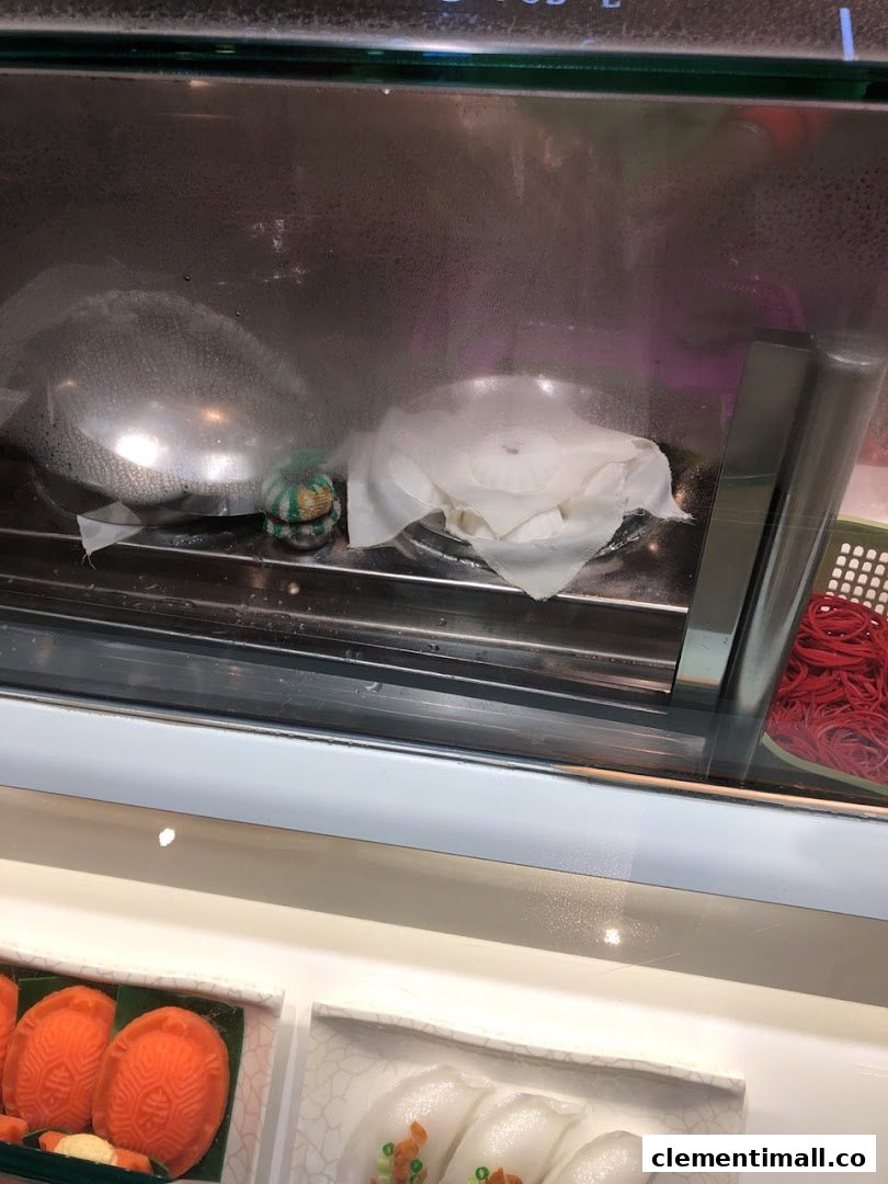 A close-up of a steamed display case showcasing traditional Asian pastries and dumplings at Eastern Rice Dumpling.