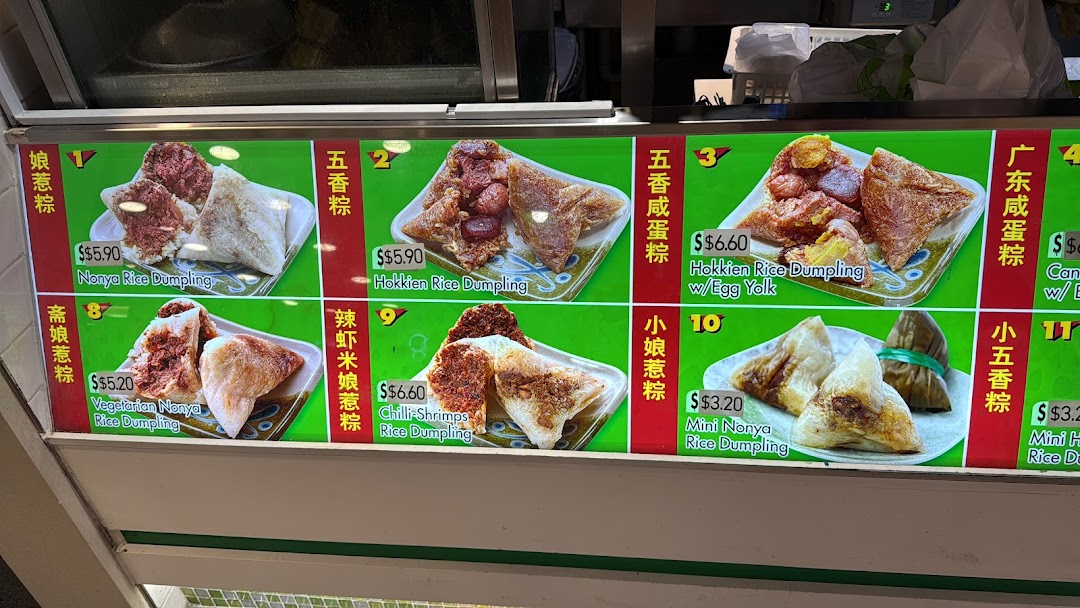 A vibrant menu board displaying various types of traditional rice dumplings with prices.