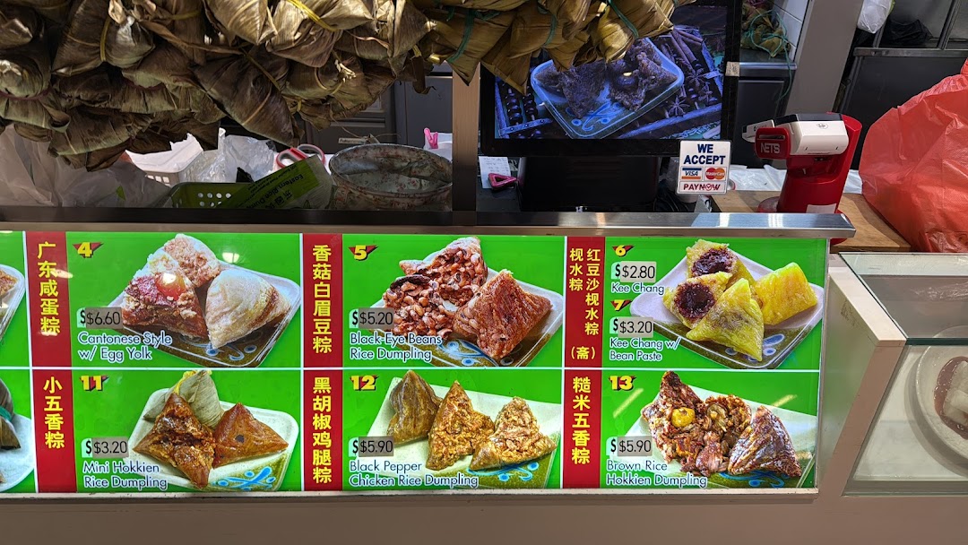 A vibrant display of various traditional rice dumplings with their prices and descriptions.
