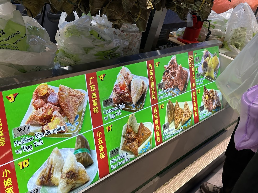 A display case showcasing various rice dumplings with prices and descriptions.