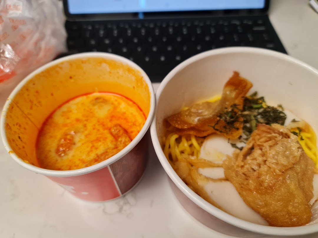 Two takeaway bowls of delicious-looking food, one with curry and the other with noodles and toppings.