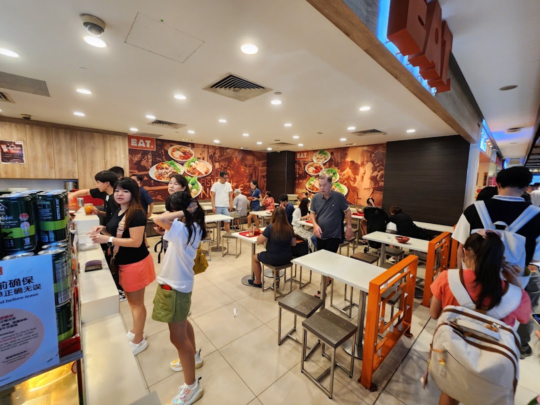 A bustling interior view of EAT, showing customers ordering and dining in a casual setting.