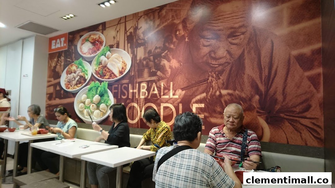 Customers dine inside EAT. restaurant, featuring a large wall mural of fishball noodles and an elderly person.