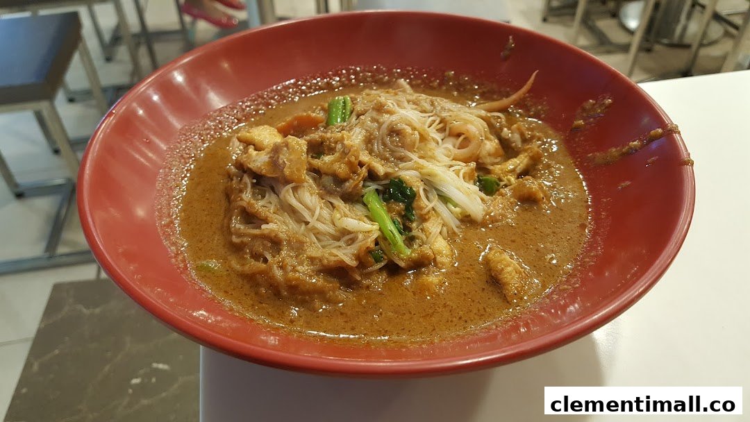A close-up of a delicious bowl of noodles with a rich, savory sauce and various toppings in a red bowl.