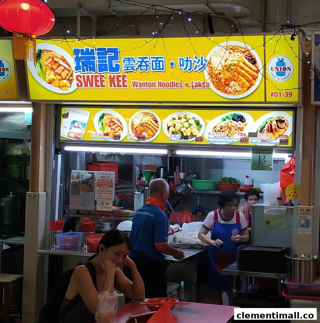 A bustling hawker stall named Swee Kee, specializing in Wanton Noodles and Laksa, with visible menu items and prices.