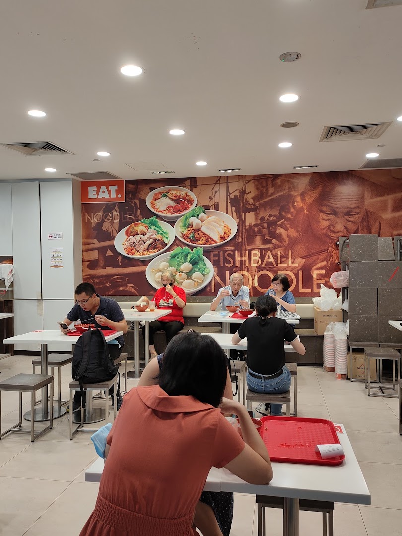 Customers enjoy meals at EAT., a casual eatery with a large wall mural featuring noodle dishes.