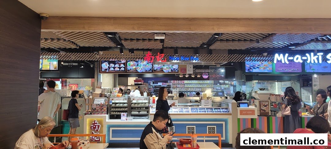 A lively food court scene featuring multiple eateries, including Nam Kee Pau, with customers dining and ordering.