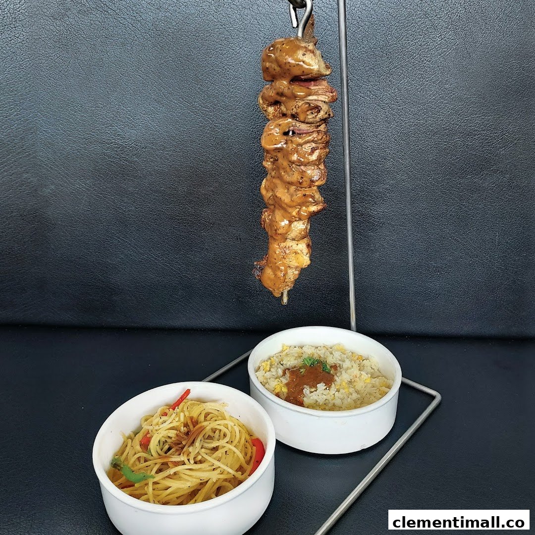 A delicious skewer of meat served with a side of spaghetti and fried rice.