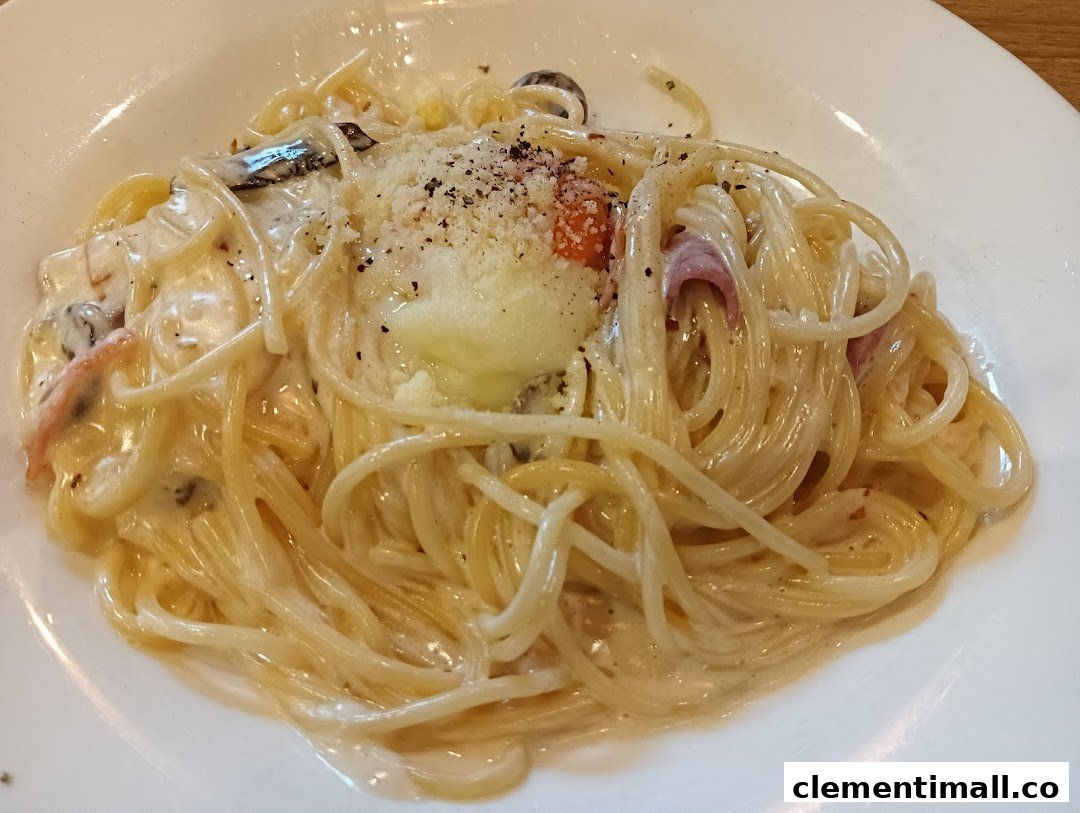 A close-up of a creamy pasta dish with a poached egg, bacon, and mushrooms on a white plate.