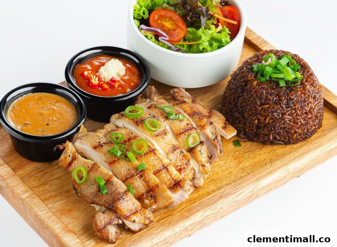 A grilled chicken dish with rice, salad, and two sauces served on a wooden board.