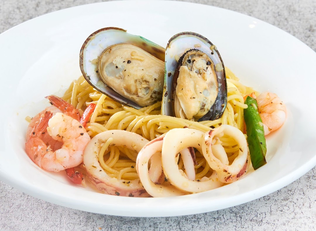 A close-up of a seafood pasta dish with mussels, prawns, and squid.