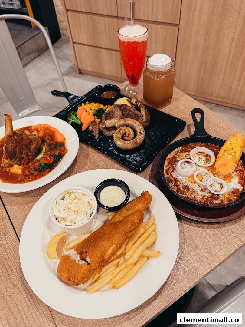 A table laden with various delicious dishes including fish and chips, lamb shank, and a mixed grill.