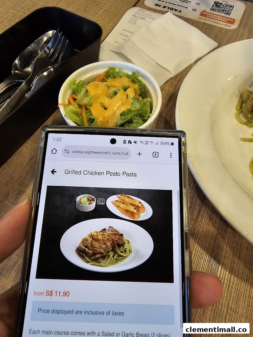 A diner's view of a table setting with a side salad and a phone displaying a menu item.