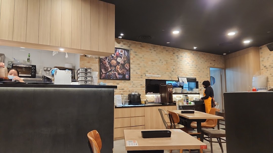 Interior view of Eighteen Chefs restaurant showing staff, kitchen counter, and dining area.