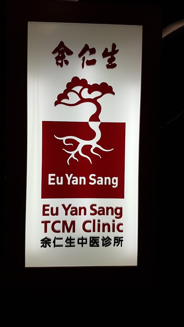 A brightly lit sign for Eu Yan Sang TCM Clinic, featuring its logo and name in English and Chinese.