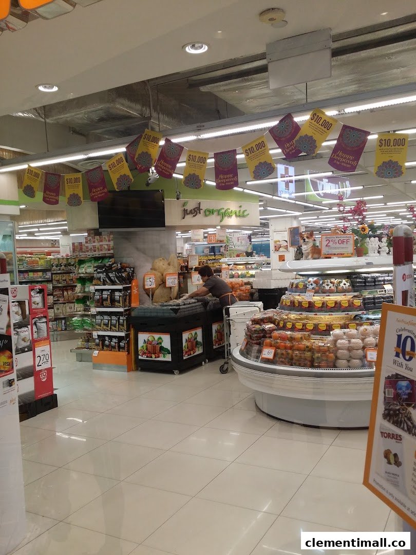 An interior view of FairPrice Finest, showcasing fresh produce, organic section, and a staff member.