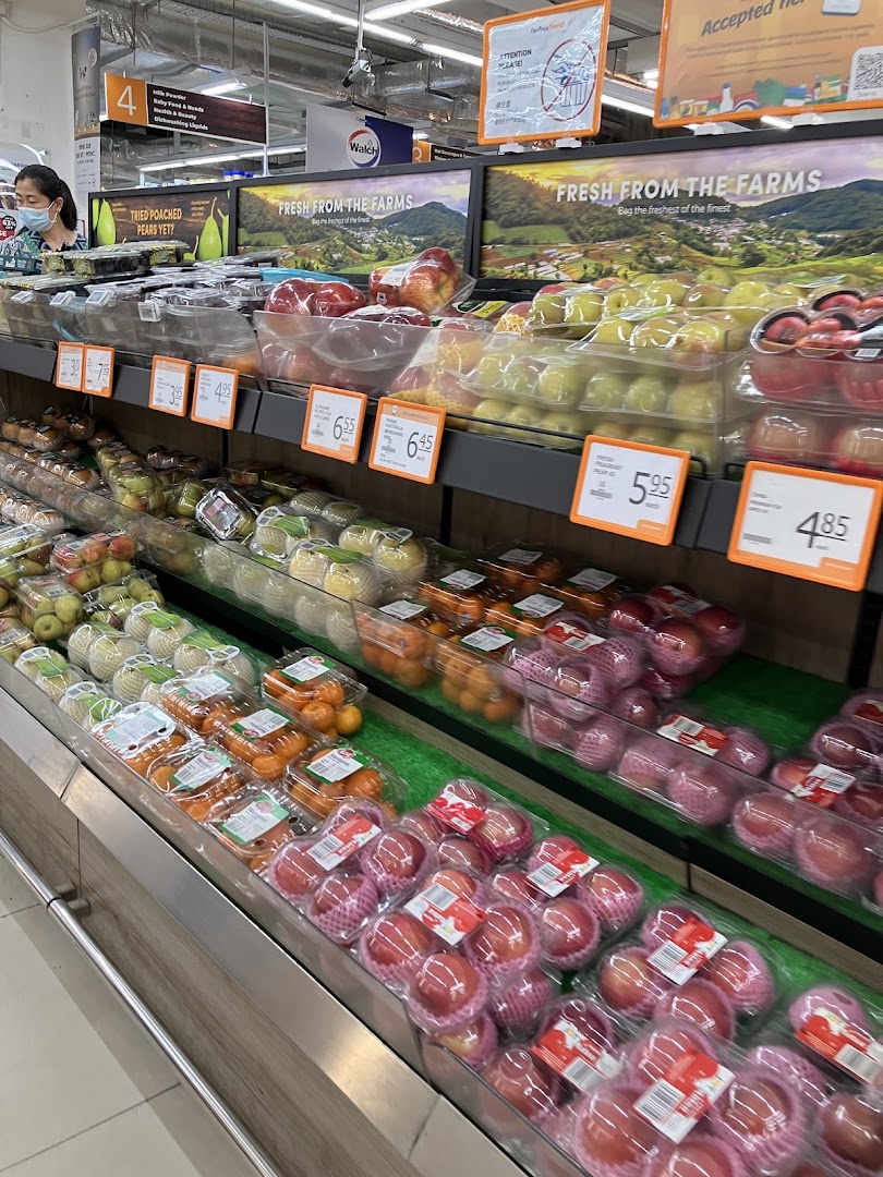 A supermarket aisle showcasing a vibrant display of fresh, packaged fruits like apples and oranges.