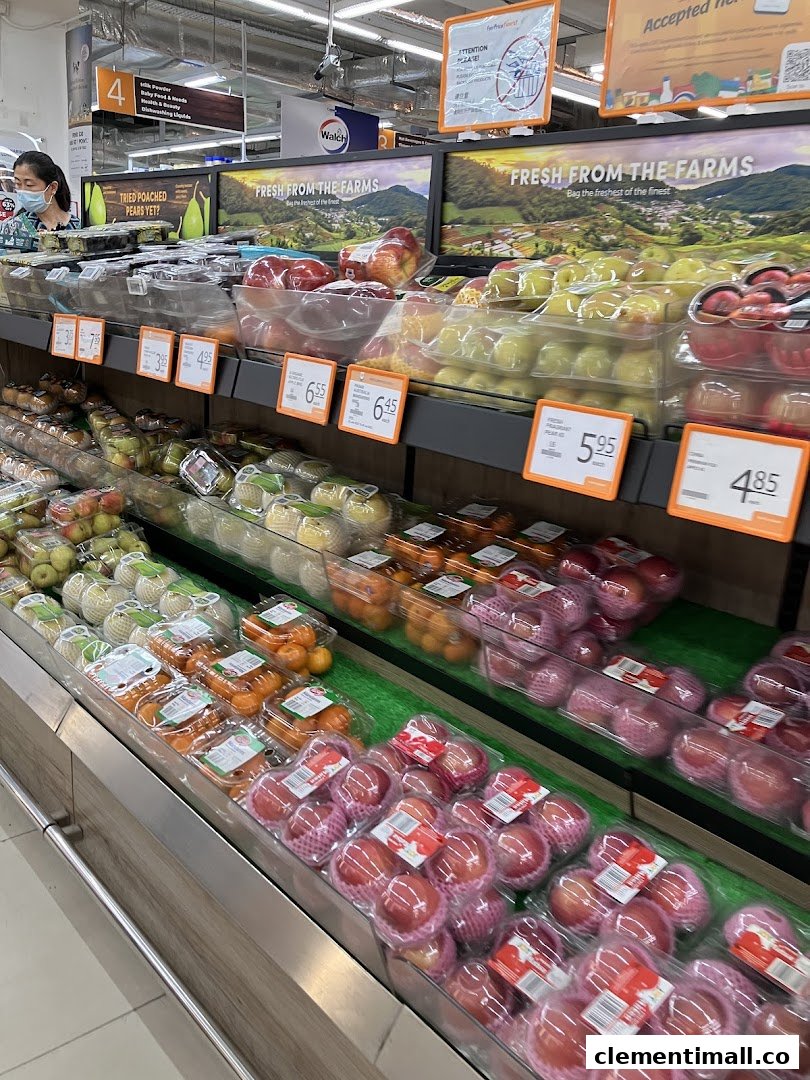 A supermarket aisle showcasing a vibrant display of fresh, packaged fruits like apples and oranges.