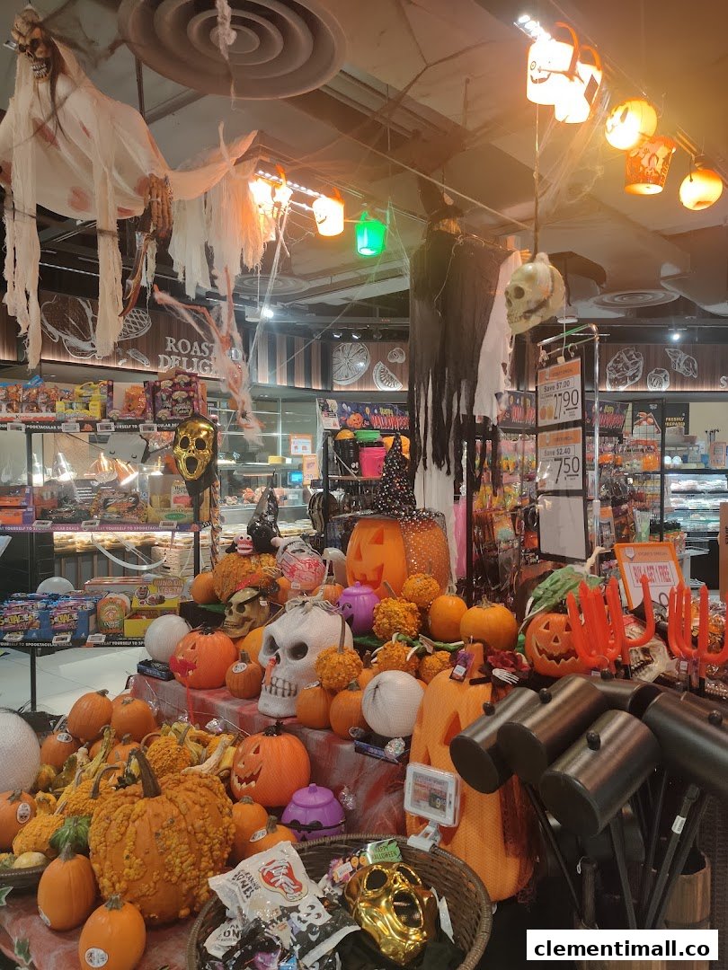 A vibrant Halloween display with pumpkins, skulls, and spooky decorations inside FairPrice Finest.