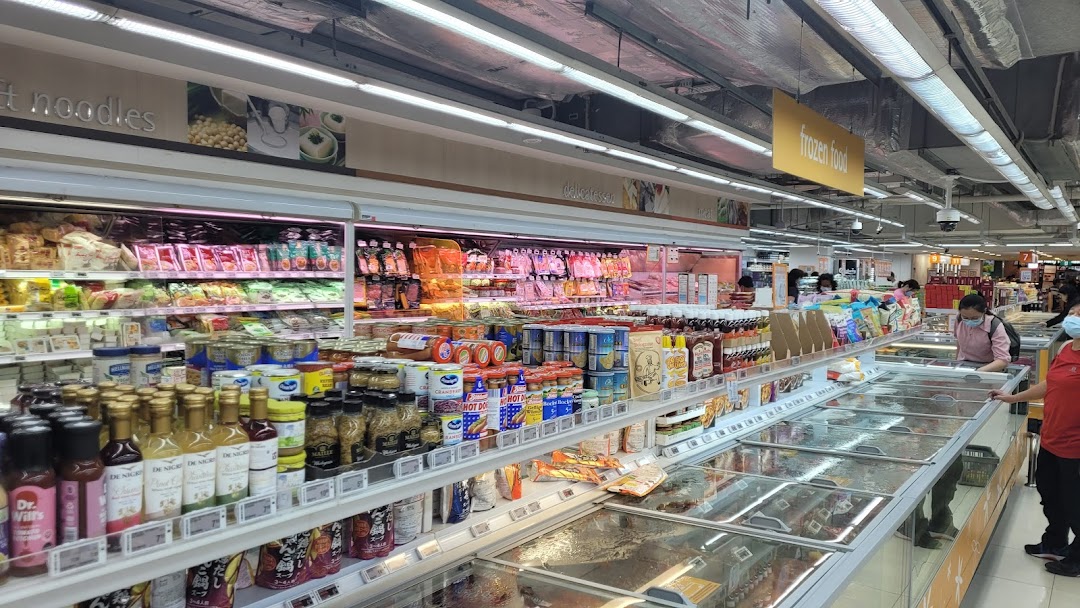 A bustling supermarket aisle at FairPrice Finest, featuring diverse groceries, fresh produce, and frozen foods.