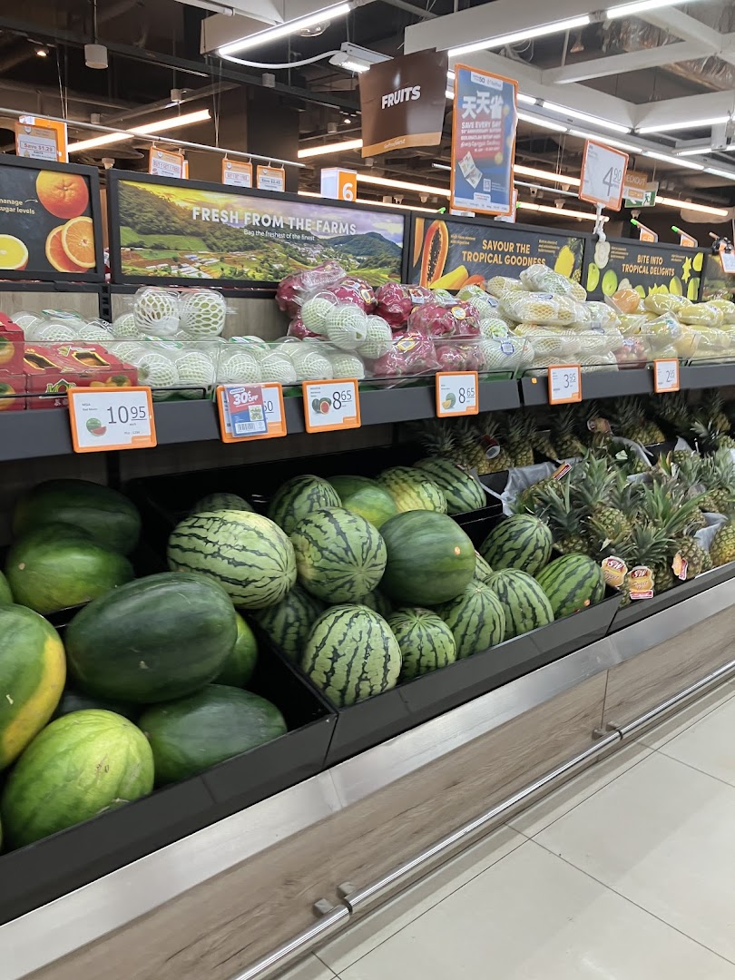 A vibrant display of fresh fruits, including watermelons and pineapples, at FairPrice Finest supermarket.