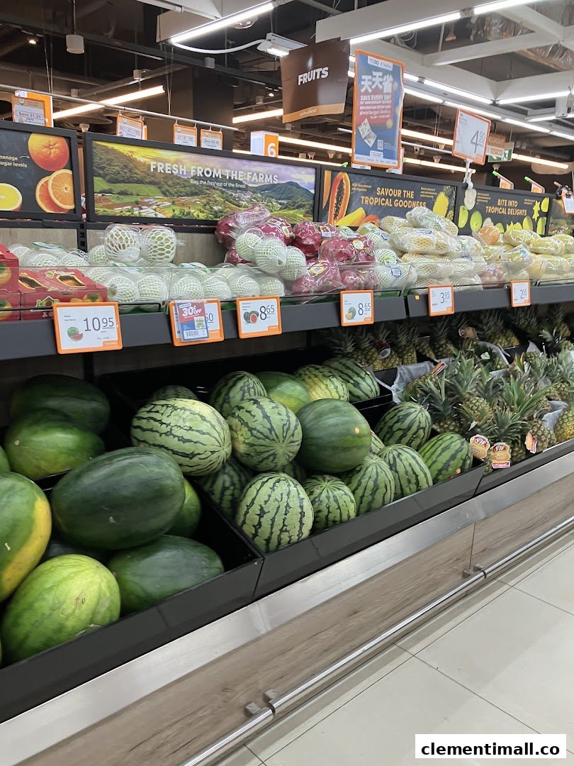 A vibrant display of fresh fruits, including watermelons and pineapples, at FairPrice Finest supermarket.