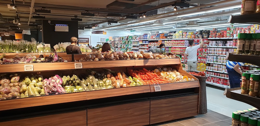An interior view of FairPrice Finest supermarket, showcasing fresh produce and grocery aisles with shoppers.