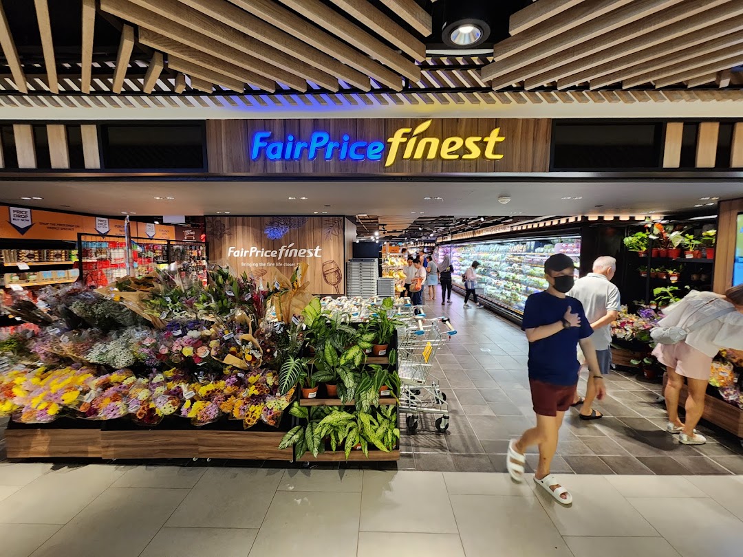 A vibrant view inside FairPrice Finest, showcasing fresh flowers, plants, and a wide array of groceries.