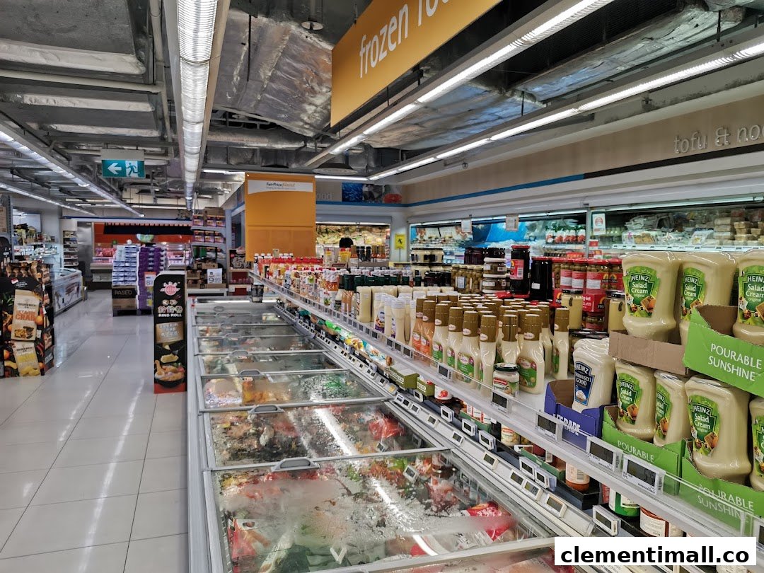 A well-stocked aisle at FairPrice Finest supermarket, featuring frozen food freezers and shelves of various grocery items.