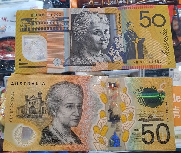 Close-up of two Australian 50 dollar banknotes, showing front and back designs.