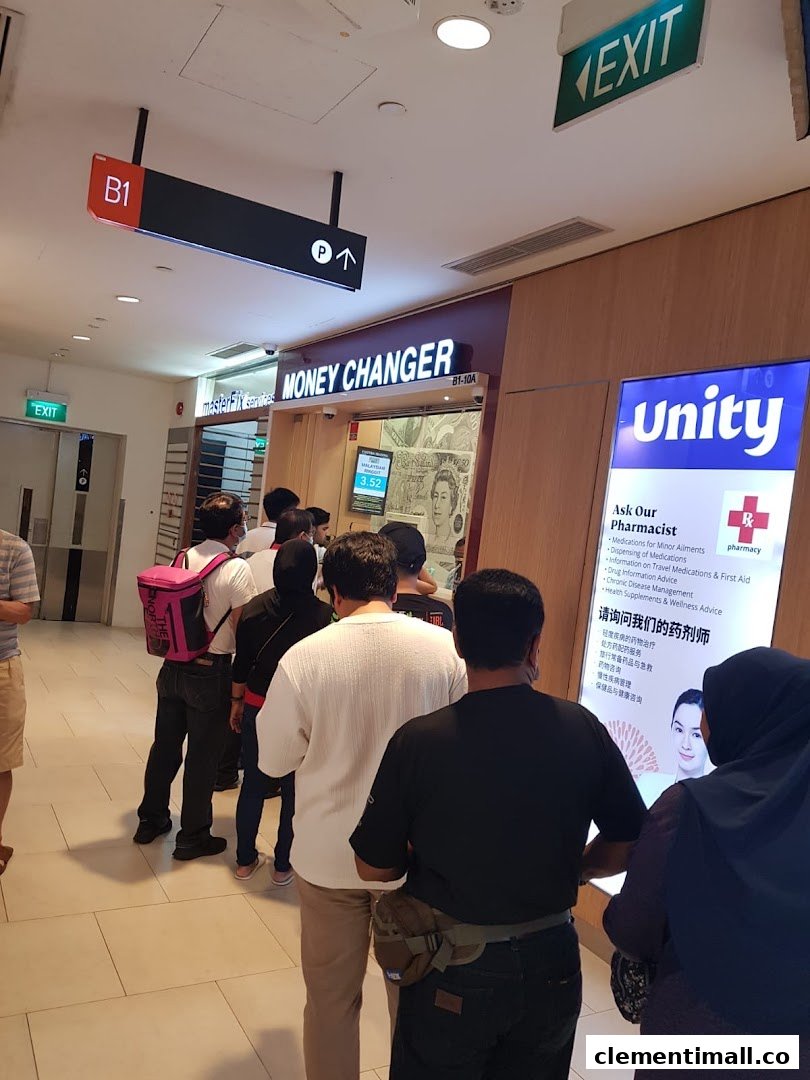 Customers queueing at Faizura Trading Clementi Money Changer counter inside a bustling shopping mall.