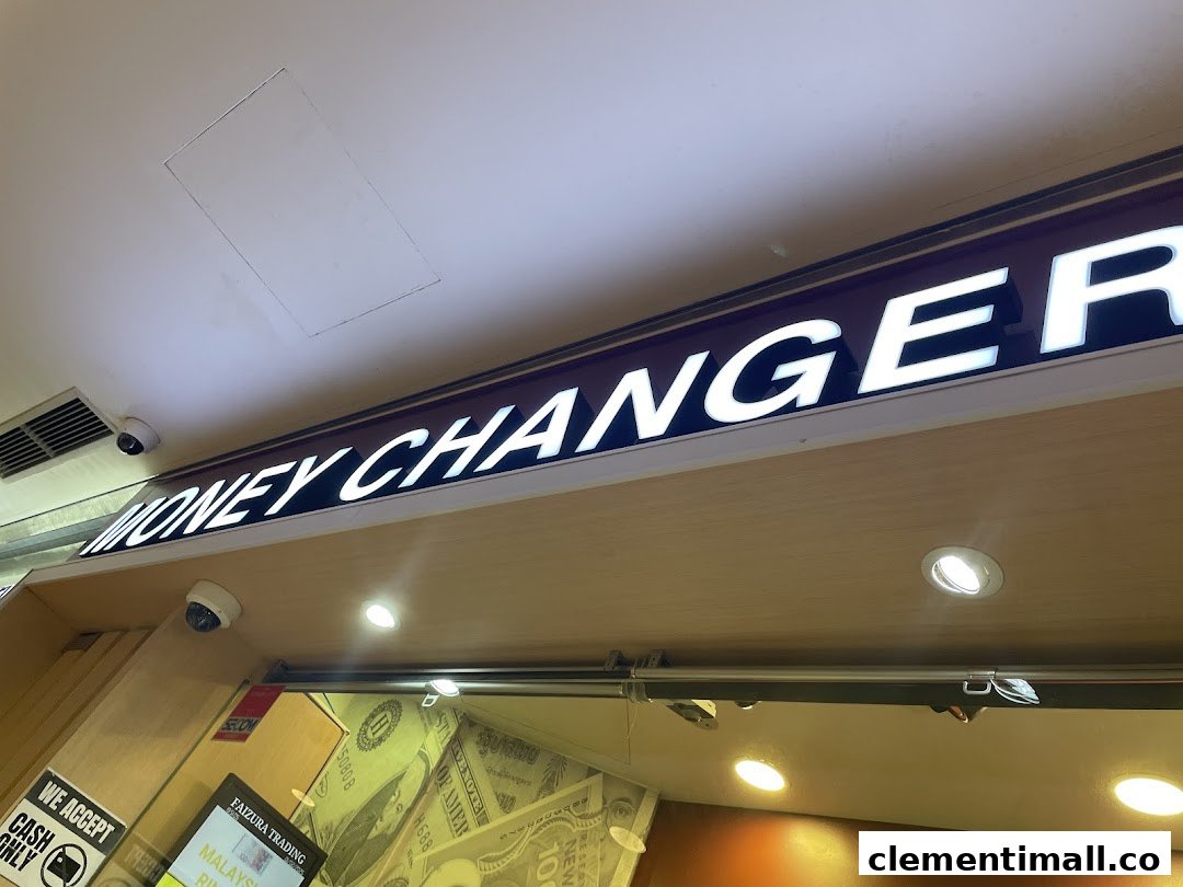 Close-up of the illuminated 'MONEY CHANGER' sign above the shop entrance.