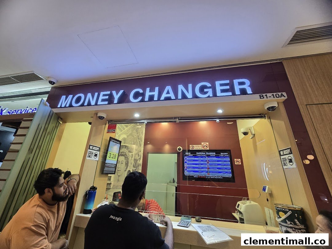 Interior view of Faizura Trading Money Changer with customers at the counter.