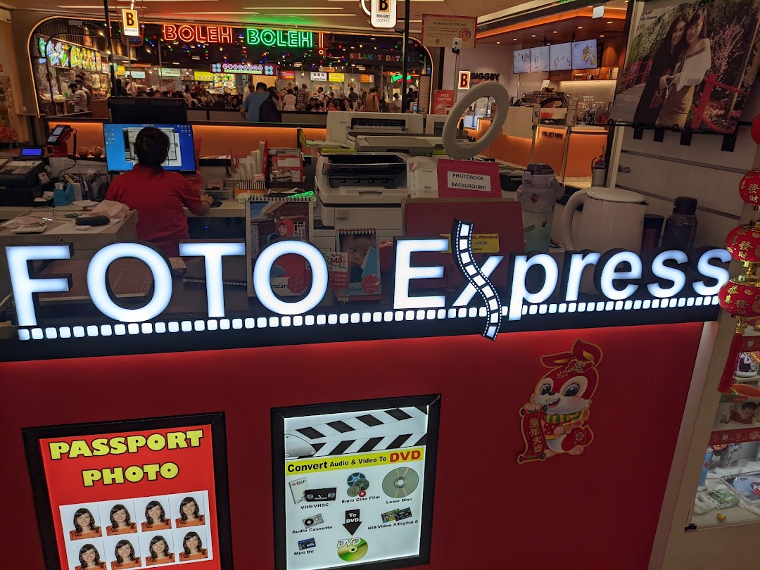 A staff member at the Foto Express counter, showcasing photo printing and media conversion services.
