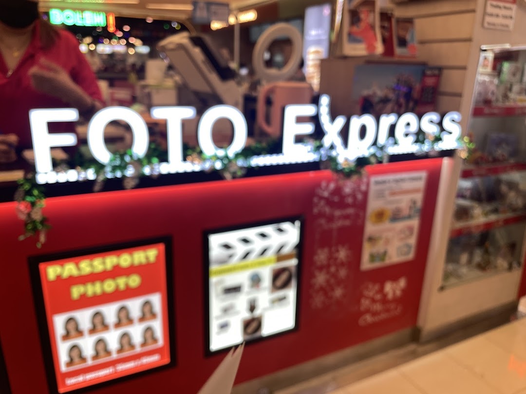 The service counter of Foto Express, featuring its illuminated sign and displays for photo services.