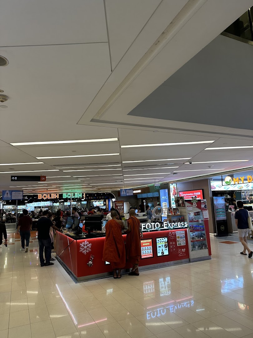 A Foto Express kiosk in a bustling mall, offering photo printing and passport services.