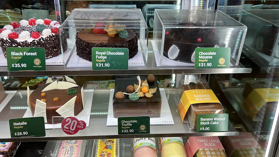 A vibrant display case showcasing a variety of delicious cakes and pastries with price tags.