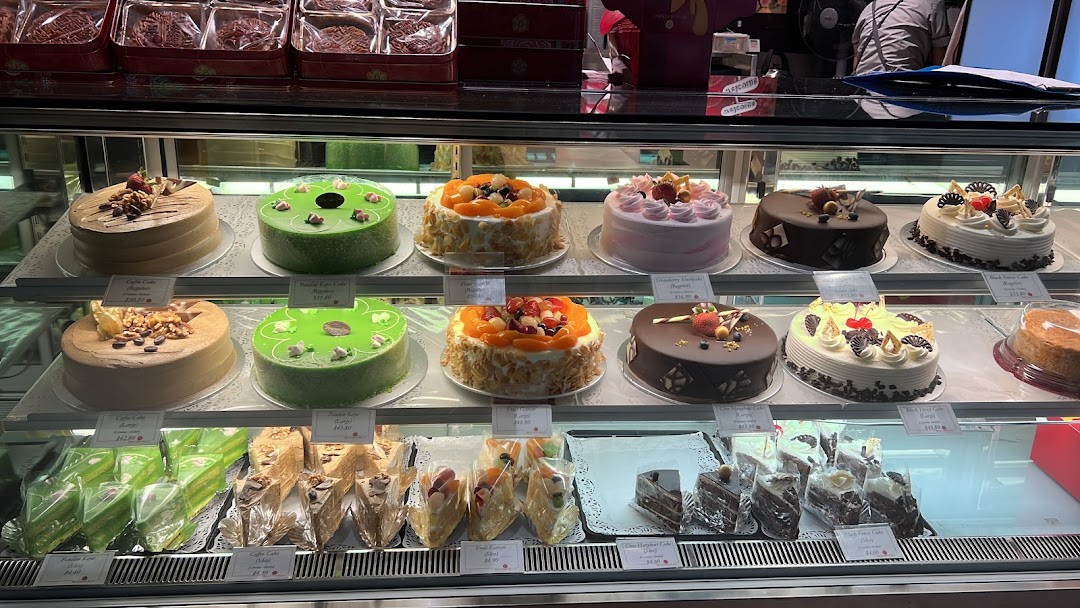 A vibrant display case showcasing a wide variety of beautifully decorated cakes and pastries.